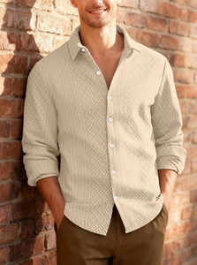 Close-up of beige knitted shirt texture with diamond pattern and button detail