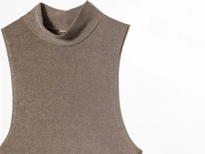 Dettaglio del top smanicato color bronzo con trama luccicante e design con collo alto tondo