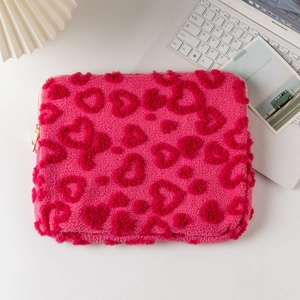 Pink plush laptop sleeve with embossed heart patterns and durable gold zipper detail