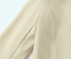 Detailed view of the shoulder seam and woven texture on this beige women blazer suit