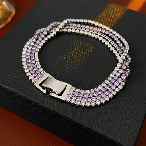 Détail d'un bracelet de tennis à quatre rangées avec zircons violets et blancs sur boîte