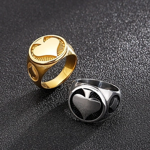 Makroaufnahme goldener und silberner Hip-Hop-Ringe mit Pik-As-Symbol aus poliertem Stahl