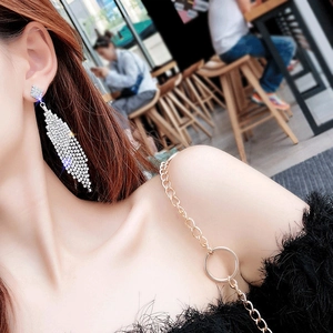 Detailed close-up of sparkling silver tassel earrings on model showing dynamic fringe effect