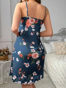 Détail d'une nuisette en satin bleu foncé avec imprimés floraux et volants délicats