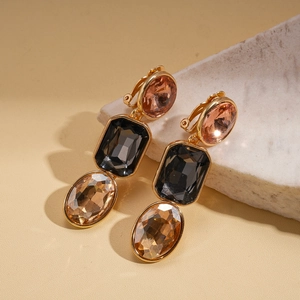 Detail view of retro geometric clip-on earrings with colorful crystals on a stone base