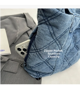 Détail d'un cabas en jean matelassé doté d'une poche latérale zippée cachée pour téléphone