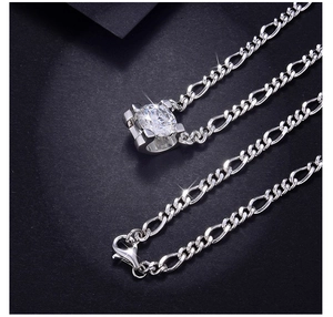 Detail of a 925 sterling silver Figaro chain necklace with a round moissanite pendant