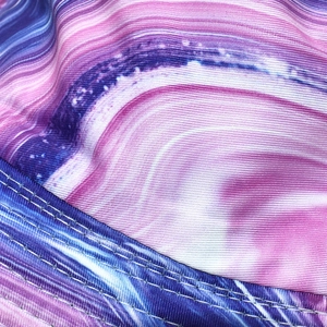 Close-up of double stitching detail on colorful tie-dye bucket hat fabric in pink and blue