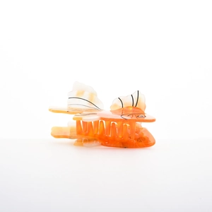 Macro detail of tropical fish hair claw clip with orange acetate and rhinestone eye