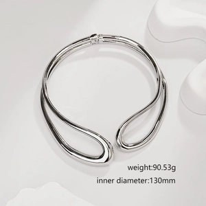 Minimalist silver irregular crossover open bangle with polished metallic finish