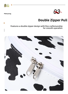 Detail of smooth double silver metal zippers on cow print travel makeup bag
