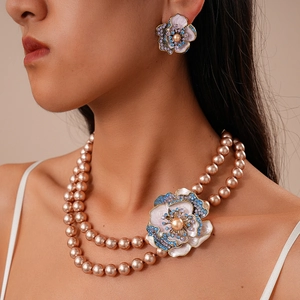 Détail du collier de perles à deux rangs et boucles d'oreilles fleuries avec cristaux
