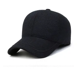 Detail view of a navy blue baseball cap with a silver metal M logo and textured fabric
