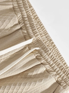 Detail of men's casual pants showing waffle knit texture and adjustable drawstring waist