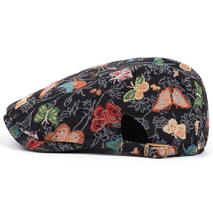 Détail d'un béret vintage avec jacquard de papillons colorés et boucle en bronze