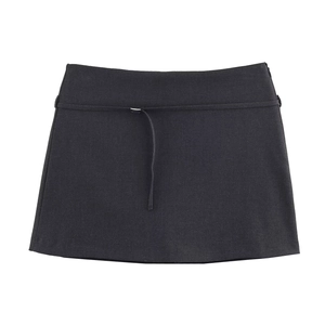 Détail de la mini-jupe trapèze noire avec ceinture fine assortie et texture du tissu