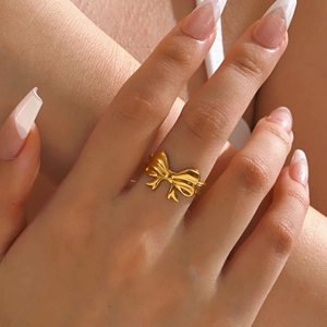 Minimalist 18K gold plated stainless steel bow ring on model finger for women