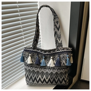 Detail of bohemian woven tote bag with fringe tassels and wave pattern textures