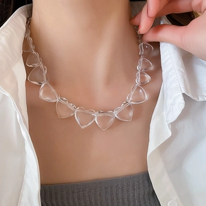 Macro detail of transparent acrylic heart-shaped beads on a choker necklace for women