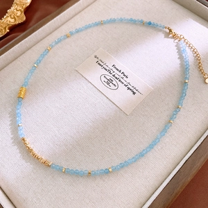 Detail of sky blue crystal beads and gold spacers on an elegant pearl necklace