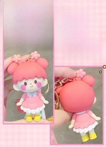 Front and back detail of a cute pink cherry blossom girl keychain in soft PVC material