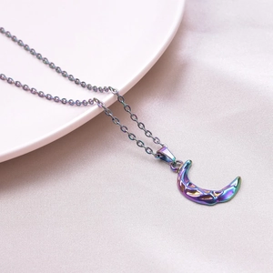 Detailed view of crescent moon necklace with colorful metallic finish and textured surface