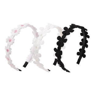 Close-up of lace sunflower embroidery on fabric headbands in black and white colors