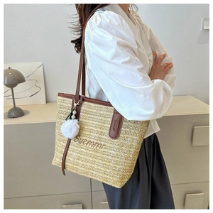 Detail of straw tote bag with Suemmr embroidery, brown PU handles and pearl pompom charm