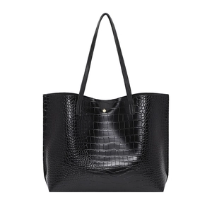 Elegant black crocodile-pattern tote bag with slim shoulder straps on white background