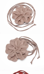 Detailed macro view of 3D leather flower accessory with long strap for belts or dresses