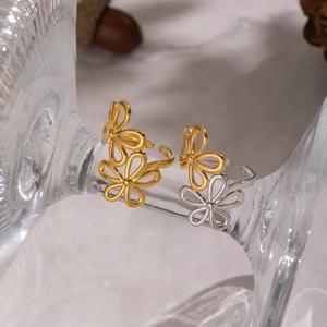 Elegant gold and silver floral cutout open rings suspended on artistic glass decor