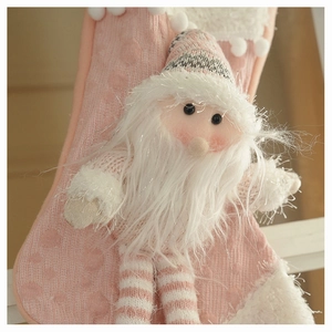 Detail of pink knitted Christmas stocking with a 3D plush Santa Claus and white faux fur trim