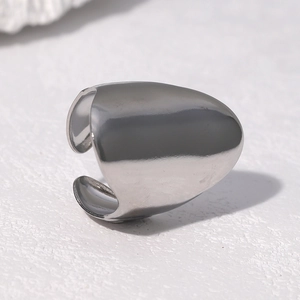 Macro shot of polished silver adjustable shield ring on white textured stone background