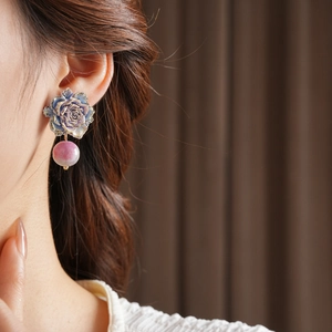 Détail d'une boucle d'oreille rose bleue rétro avec perle dégradée violette portée