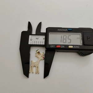Detail view of a gold deer pendant measured by a digital caliper showing 18.5 mm size