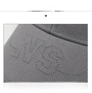 Close-up of grey baseball cap showing breathable mesh fabric and letter embroidery details