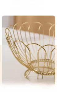 Close-up of golden iron fruit basket showing smooth metal lines and fine mesh bottom