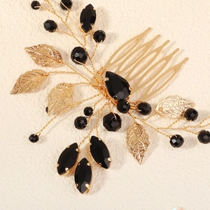 Detailed view of handmade gold bridal hair comb with black beads and hollow metal leaves