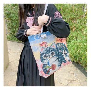 Canvas shoulder bag with cat print and cotton rope handles worn by a model outdoors