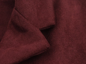 Close-up detail of burgundy faux suede jacket showing soft fabric texture and warm material