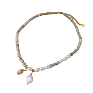 Handmade necklace with freshwater pearls, colorful beads, and sea shell pendant on white