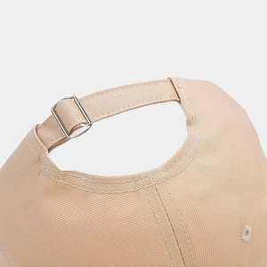 Detail of adjustable cotton baseball cap strap with silver metal buckle in beige