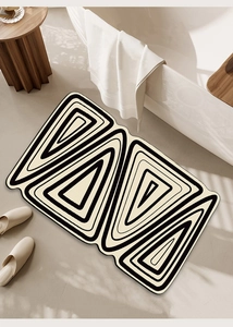 Detail view of anti-slip bathroom mat with geometric black and cream triangle patterns
