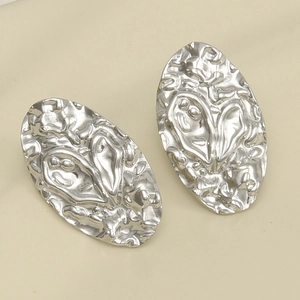 Macro shot of silver pleated stainless steel earrings with unique irregular texture