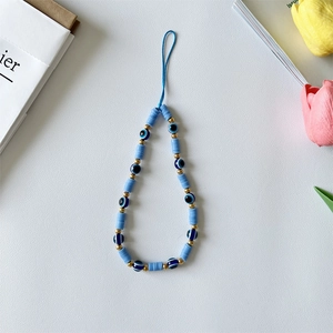 Detail of blue evil eye beaded phone strap with ceramic heishi beads and gold accents