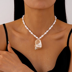 Marine style seashell and pearl beaded necklace worn on a female model's collarbone