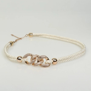 Detail of white braided cord and gold chain accessory with adjustable clasp and metal rings