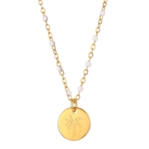 Macro view of gold palm tree engraved pendant with delicate white beaded chain necklace