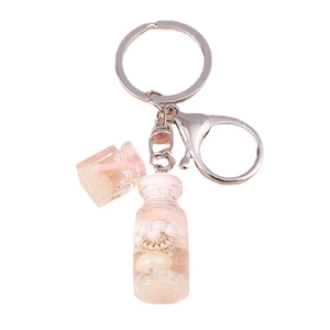 Pink wishing bottle keychain with shells and pearls inside, clear background