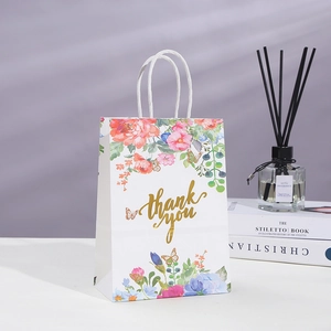 White floral kraft paper gift bag with golden thank you text and paper handles